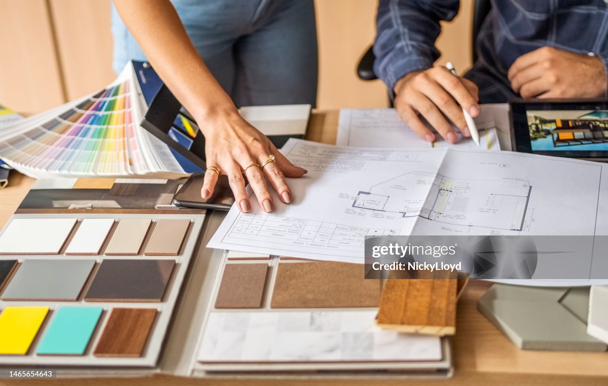 Cropped shot of a male architect discussing building blueprints with female colleague during meeting in office